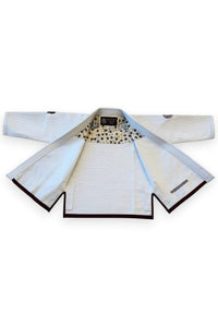 ENIGMA Kimonos white BJJ gi jacket with maroon trim, floral interior lining, and reinforced cotton weave construction.