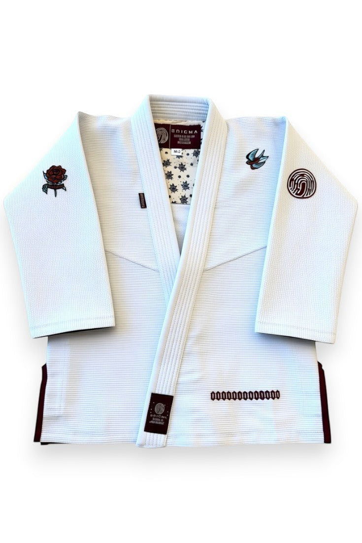 ENIGMA Kimonos white BJJ gi jacket with maroon trim, rose and swallow embroidery, and patterned interior lining.