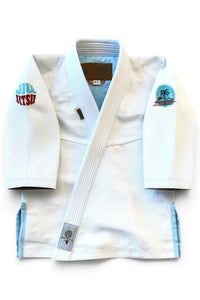 ENIGMA Kimonos white BJJ gi with tropical embroidery, light blue accents, and reinforced stitching for youth athletes.